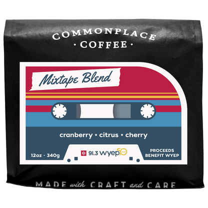 A black bag of 12oz Mixtape Blend from Commonplace Coffee. The label is red, yellow, and blue, and looks like a retro cassette tape.